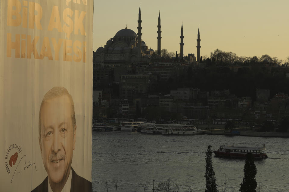 In this Monday, March 11, 2019 photo, a poster of Turkey's President Recep Tayyip Erdogan, is seen backdropped by the Golden Horn and Suleymaniye Mosque, in Istanbul, ahead of local elections scheduled for March 31, 2019. For Turkish President Recep Tayyip Erdogan, Sunday’s local elections are about Turkey’s future national “survival.” After 17 years in office, the Turkish leader has a tight grip on power, but he is campaigning hard for the strong mandate that he says he needs to protect Turkey against threats from domestic and foreign enemies. Analysts say the rhetoric is aimed at diverting attention away from rising inflation, a sharp increase in food prices and high unemployment. (AP Photo/Emrah Gurel)