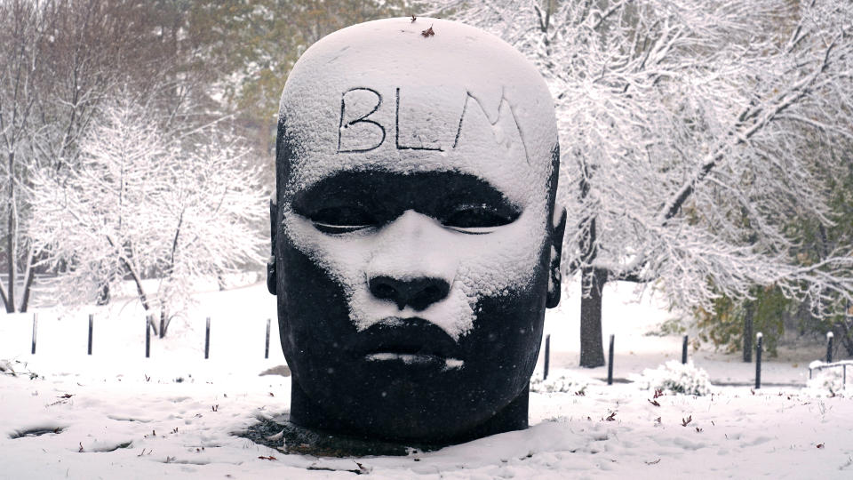 The abbreviation "BLM", for the Black Lives Matter movement, written on the forehead of the "Eternal Presence" statue outside the National Center of Afro-American Artists, Friday, Oct. 30, 2020, in the Roxbury neighborhood of Boston. The Boston area was blanketed with a few inches of snow during the day. (AP Photo/Charles Krupa)