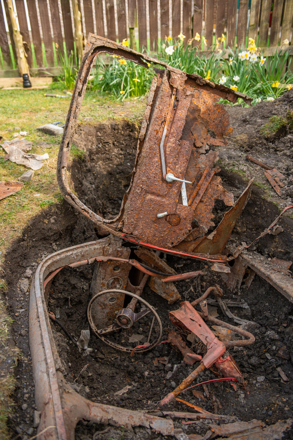 The dad-of-two has no idea how the car ended up buried under his lawn. (Picture: SWNS)