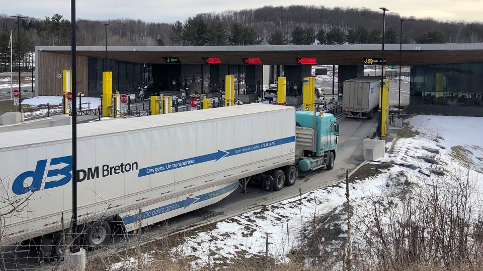 Trucks from Canada wait to cross the border into the United States in March 2020, in Derby Line, Vt.