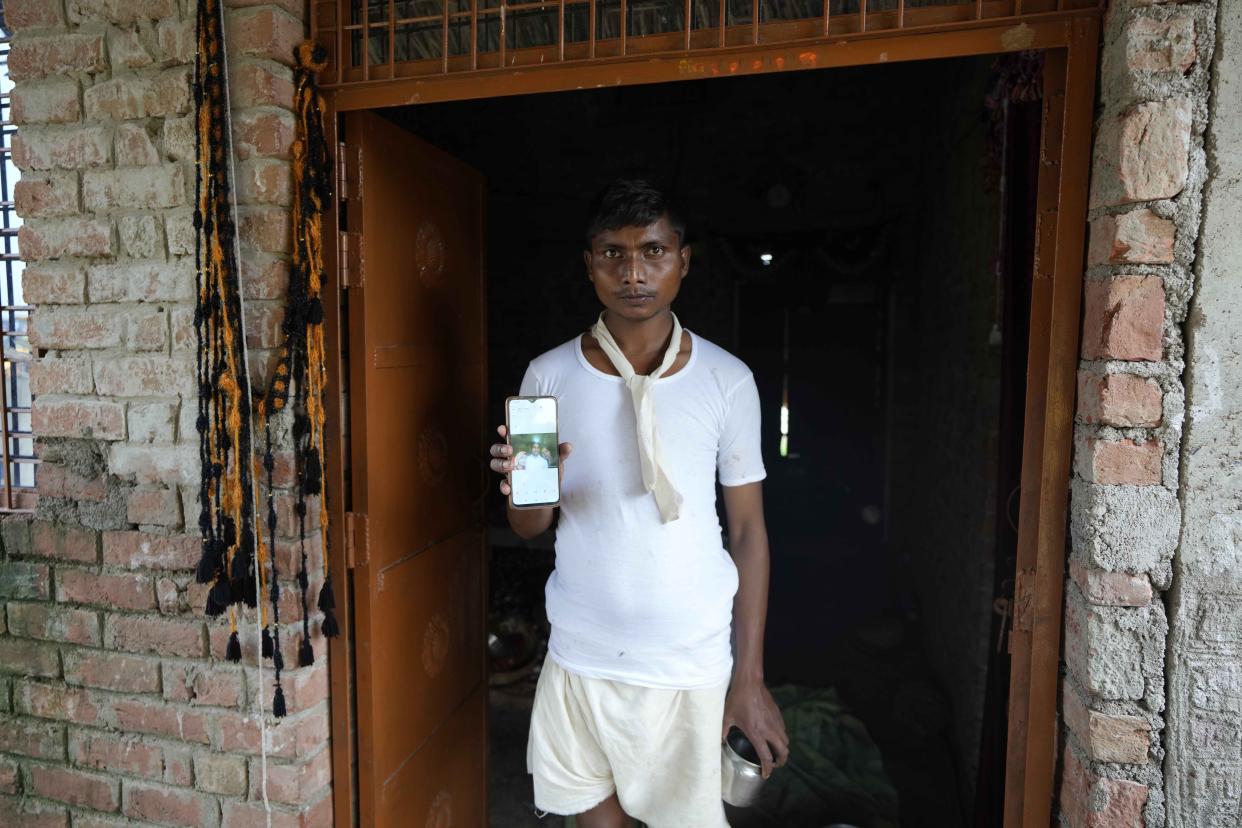 Sushil Kumar Bind displays a photograph of his wife Khushboo who was killed by lightning on June 25 in a paddy field at Piparaon village on the outskirts of Prayagraj, in the northern Indian state of Uttar Pradesh, Thursday, July 28, 2022. Seven people, mostly farmers, were killed by lightning in a village in India's northern Uttar Pradesh state, police said Thursday, bringing the death toll by lightning to 49 people in the state this week. (AP Photo/Rajesh Kumar Singh)