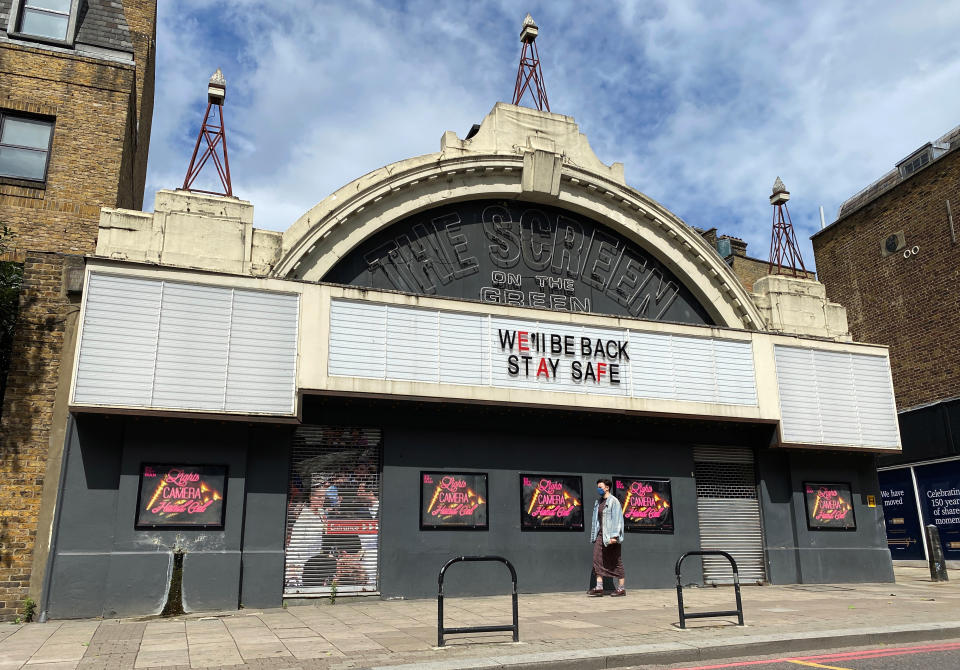 A person wearing a face covering walks past The Screen on the Green cinema in Islington, part of the Everyman chain, which was closed following the coronavirus (COVID-19) outbreak, London, Britain, July 3, 2020.   REUTERS/Simon Newman