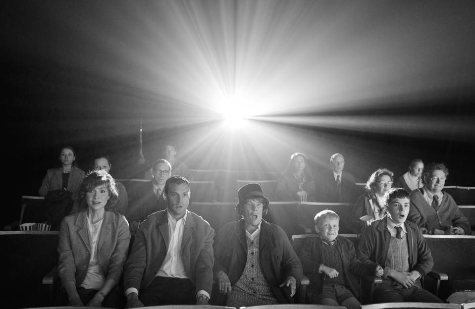 An Irish family (from left, Caitriona Balfe, Jamie Dornan, Judi Dench, Jude Hill and Lewis McAskie) are wowed at the movies in Kenneth Branagh's "Belfast."