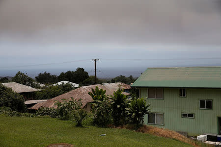 A volcanic ash cloud hovers in the distance during the eruption of the Kilauea Volcano in Pahala, Hawaii, U.S., May 23, 2018. REUTERS/Marco Garcia