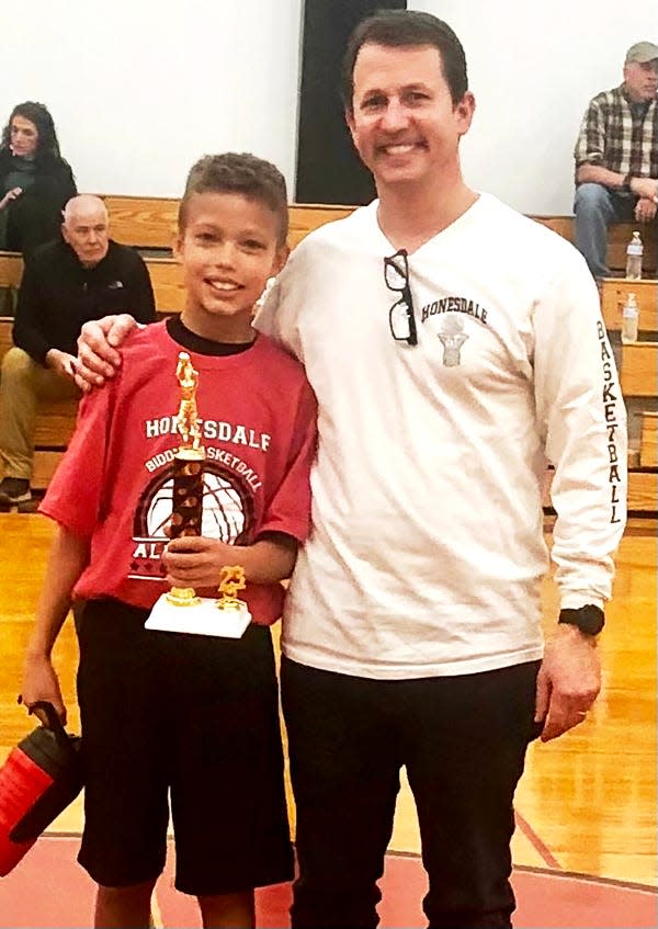 Harvey Waugh Jr. is this year's Honesdale Biddy Basketball Senior Division free throw shooting champ. He's pictured here receiving the Ed martin. Sr. Memorial trophy from AG Howell.