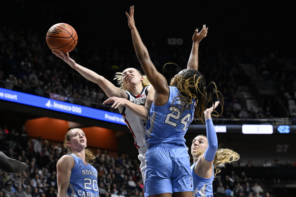 UConn guard Paige Bueckers shoots as North Carolina guard Indya Nivar (24) defends in the first half of an NCAA college basketball game, Sunday, Dec. 10, 2023, in Uncasville, Conn. (AP Photo/Jessica Hill)