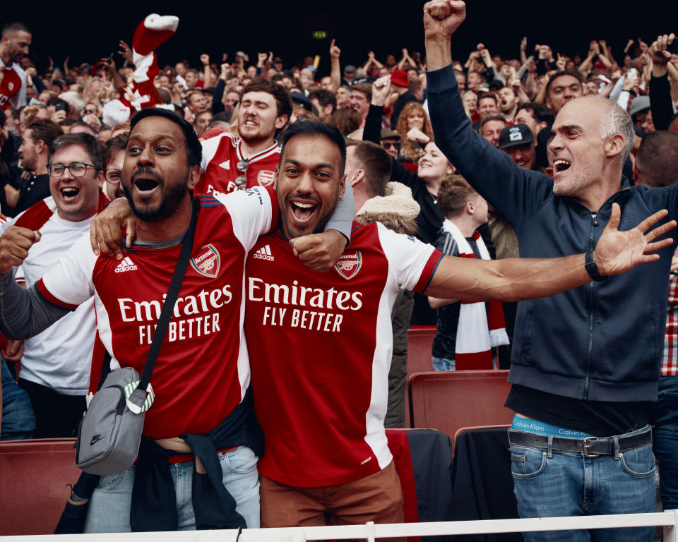 Aficionados del Arsenal ondean banderas mientras los jugadores salen a la cancha del Emirates Stadium, en Londres, el 1.° de octubre de 2022. (Ben Quinton/The New York Times)