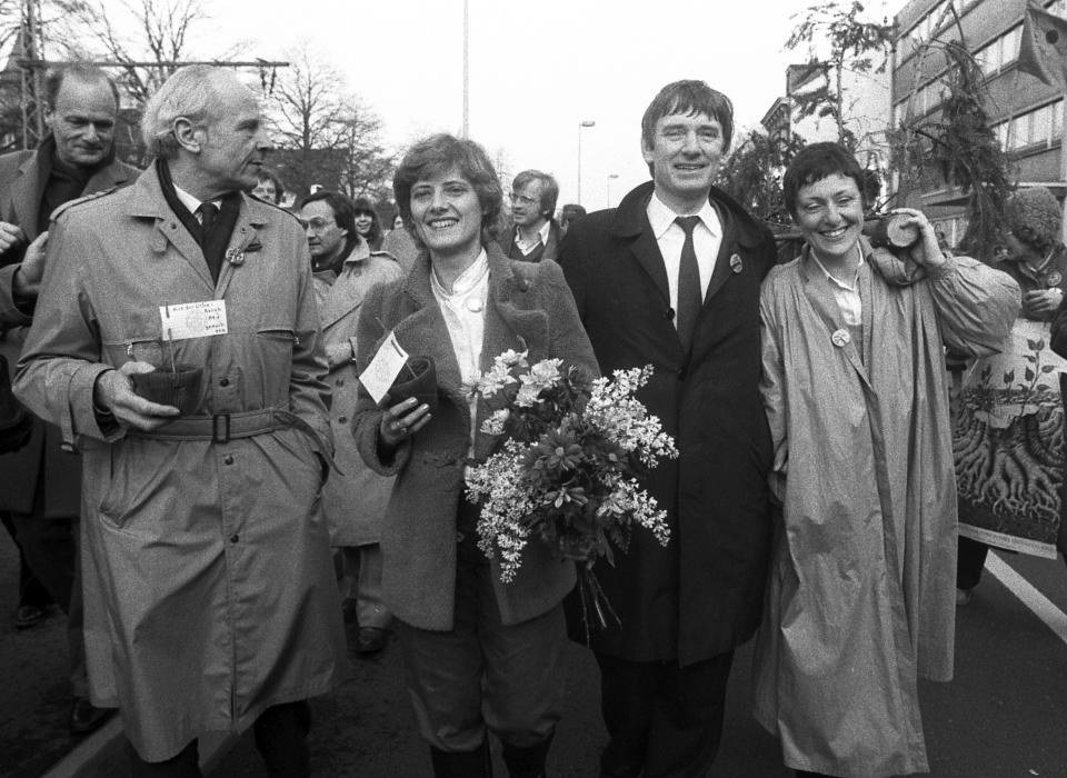 FILE - In this March 29, 1983 file photo leaders of the Greens, former General Gert Bastian his companion Petra Kelly, Otto Schily, and Marieluise Beck-Oberdorf, from left, carry flowers and potted conifers as they lead a parade of Green party members and supporters as they walk towards the Bundestag (West German parliament) before entering the building in Bonn, West Germany. While other German mainstream parties flounder in polls and struggle to find an answer to a far-right challenge, the Greens have gone from strength to strength over the last year. Their current flexibility would have been hard to imagine in 1983 when the Greens, then a protest party with a penchant for beards and sunflowers, first took their seats in the German parliament. (AP Photo)