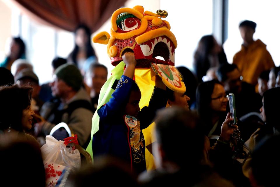 A child in a lion costume watches GQ Lion Dance from the Giac Quang Temple perform during a Lunar New Year celebration hosted by the  Vietnamese American Community of Oklahoma at the Dove Event Center in Oklahoma City, Saturday, Jan. 14, 2023.