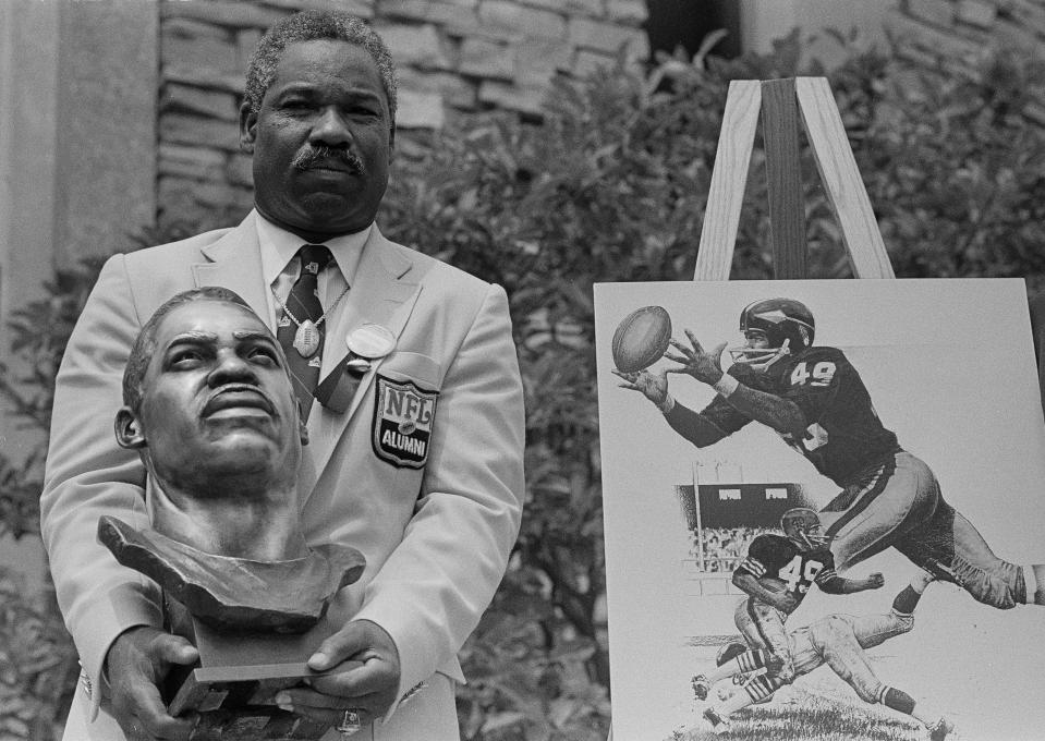 Former Cleveland Browns and Washington Redskins halfback and wide receiver Bobby Mitchell poses with his bronze bust after being inducted into the Pro Football Hall of Fame in ceremonies in Canton, Ohio, July 30, 1983.  (AP Photo/Gus Chan)