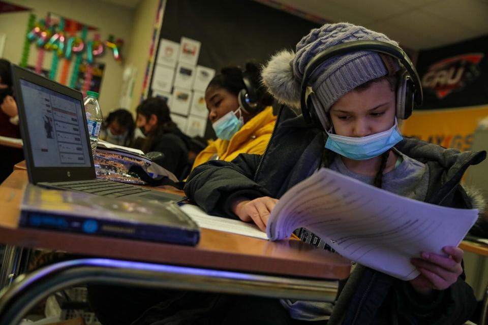 A fifth-grader wears a mask in her class.