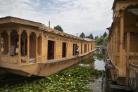 Kashmiri man Illiyas Ahamad cleans an unoccupied houseboat at Nigeen Lake during lockdown to stop the spread of the coronavirus in Srinagar, Indian controlled Kashmir, July 16, 2020. Indian-controlled Kashmir's economy is yet to recover from a colossal loss a year after New Delhi scrapped the disputed region's autonomous status and divided it into two federally governed territories. (AP Photo/Mukhtar Khan)