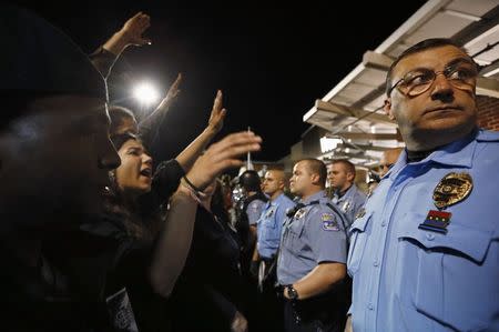 Protesters take part in a demonstration in front of police officers at a Walmart store in St. Louis, Missouri, October 13, 2014. REUTERS/Jim Young