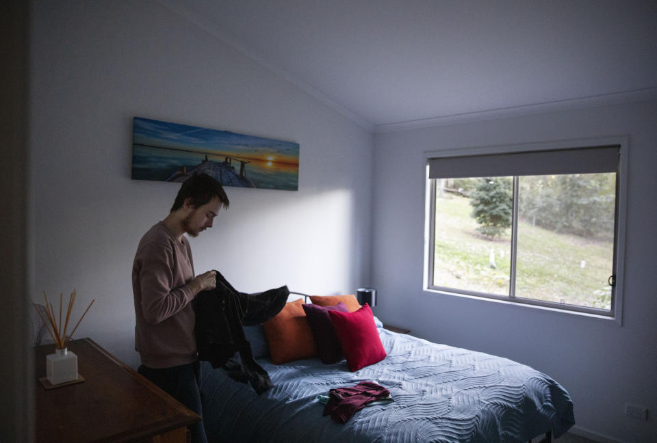 Sam Ware, 22, packs some clothes from his mother's home upon returning for the first time since overdosing there three weeks earlier, in Fountaindale, Central Coast, Australia, Friday, July 19, 2019. He's hoping she'll let him stay but this is what Deb's been dreading. She tells herself that coddling him is enabling him. That if she lets him get one foot in the door, he will force his way back into her life until the inevitable, awful end of his own. (AP Photo/David Goldman)