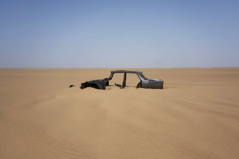 The frame of an abandoned Peugeot 404 lies in the south central Sahara, June 2018