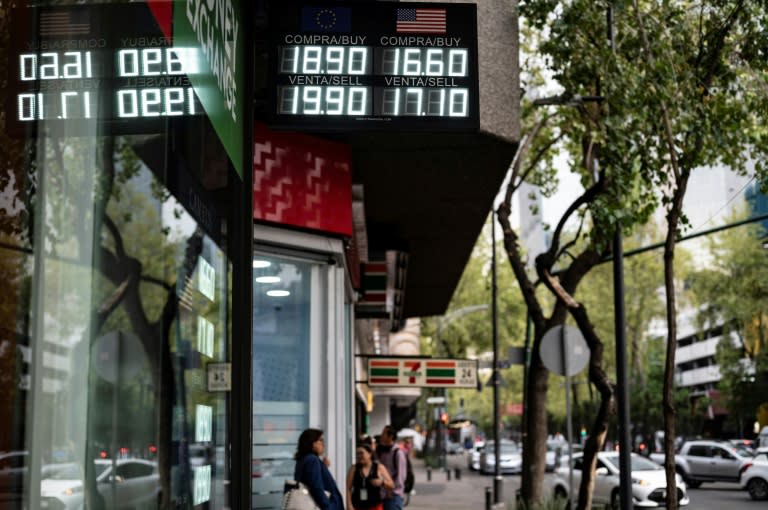 Una casa de cambio muestra una pantalla con el tipo de cambio de dólares y euros en Ciudad de México el 6 de junio de 2024 (Yuri CORTEZ)