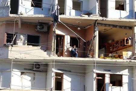 A man sits on the balcony of his damaged house in the rebel held besieged al-Sukkari neighbourhood of Aleppo, Syria October 19, 2016. REUTERS/Abdalrhman Ismail