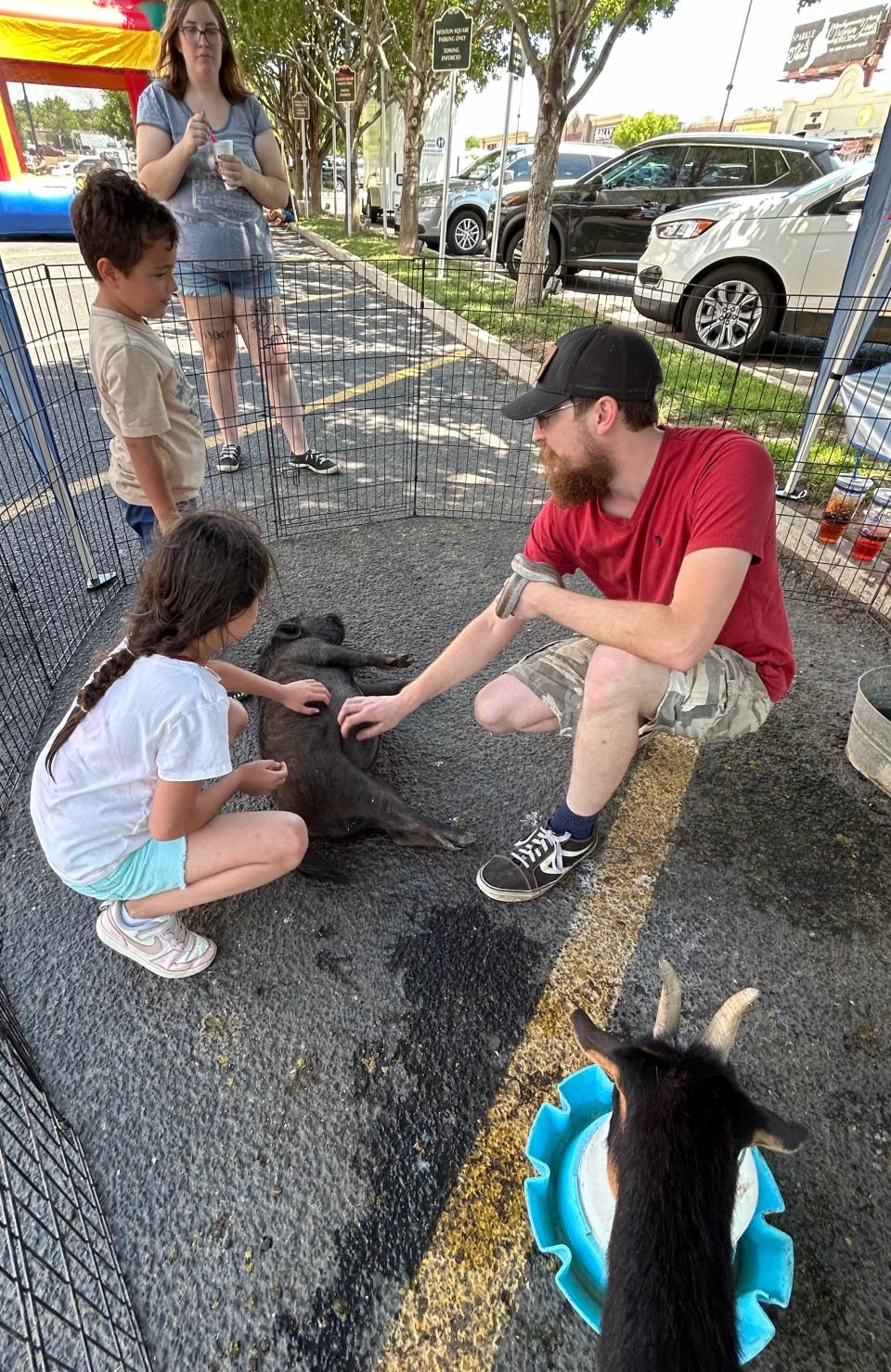 The Petting Zoo owned by Ryder and Mallory Woodson of Fritch was a very popular place on Friday at The Shops at Wolflin. Ryder shows a young girl how to rub the belly of the friendly Amazon Guinea. They also had a snake, a Nigerian Dwarf Pigmy goat and various ducks and chickens.