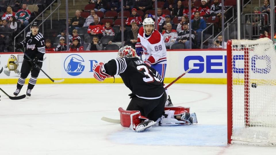 Montreal Canadiens center Jake Evans scores a goal on New Jersey Devils goaltender Andrew Hammond