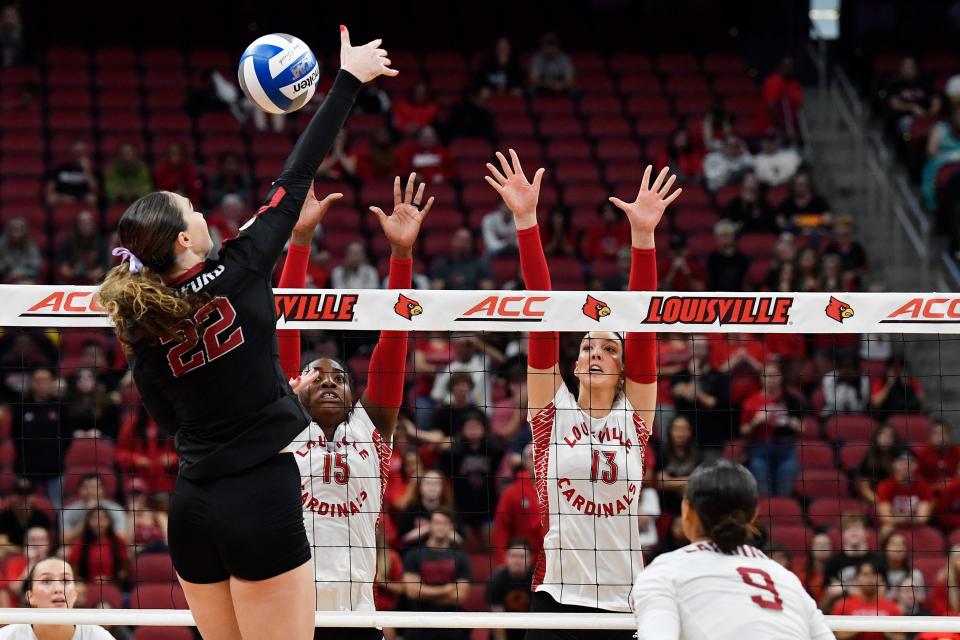 Louisville's Aiko Jones (15) and Cara Cresse (13) go up in an attempt to block a scoring attempt by Stanford's Caitie Baird (22) during the fifth game of the Cardinals' match against Stanford, Sunday, Sept. 17, 2023, in Louisville Ky. Louisville lost to Stanford 3-2