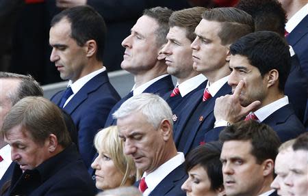 Liverpool's Luis Suarez (R) reacts during a memorial service to mark the 25th anniversary of the Hillsborough disaster at Anfield in Liverpool, northern England April 15, 2014. REUTERS/Darren Staples