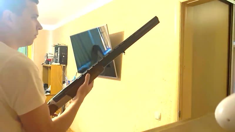 A man holds a weapon during a raid conducted by Belarusian security officers in Minsk