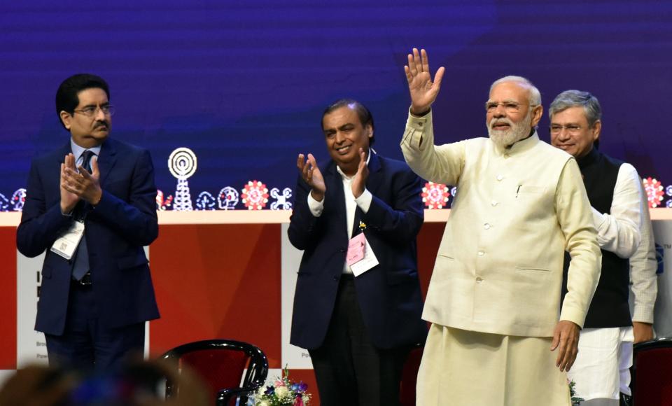 Mukesh Ambani stands next to Indian Prime Minister Narendra Modi at an event celebrating the launch of 5G services in India.