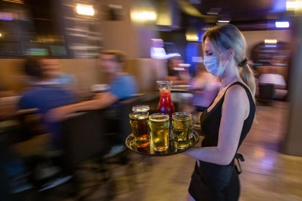 Restaurant owners and managers around Ottawa say it's busier than ever as COVID-19 restrictions continue to ease in Ontario — but finding enough workers to serve those all those hungry and thirsty diners is proving a big problem. (Lars Hagberg/The Canadian Press - image credit)