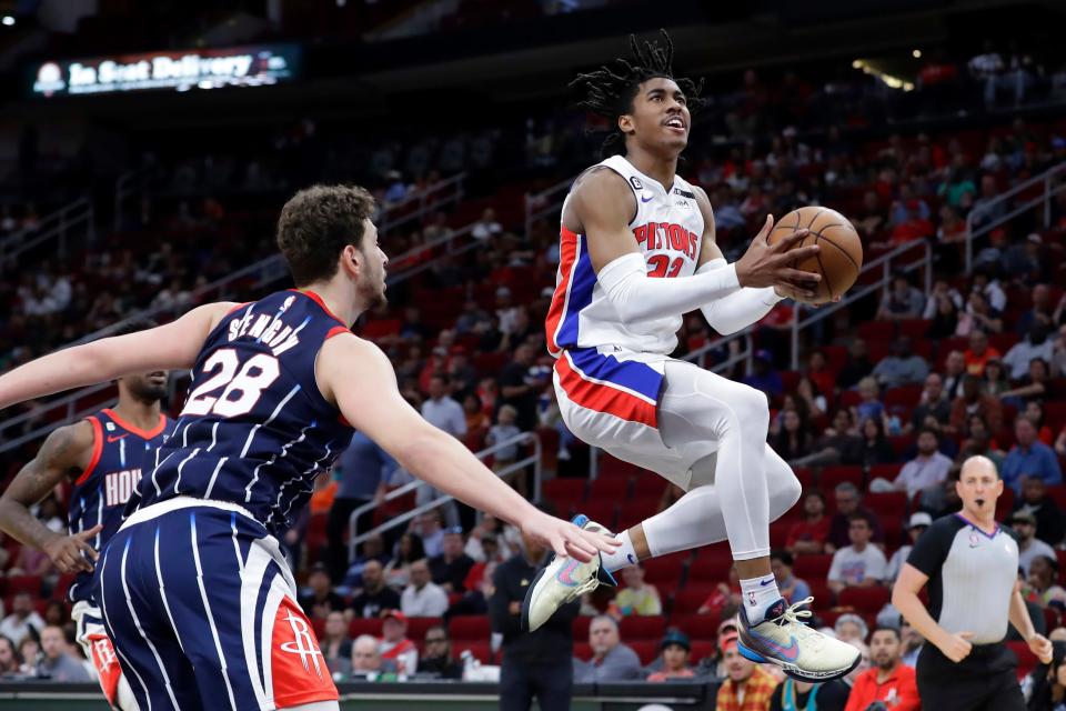 Detroit Pistons guard Jaden Ivey lays up a shot in front of Houston Rockets center Alperen Sengun, front left, during the first half at Toyota Center in Houston on Friday, March 31, 2023.