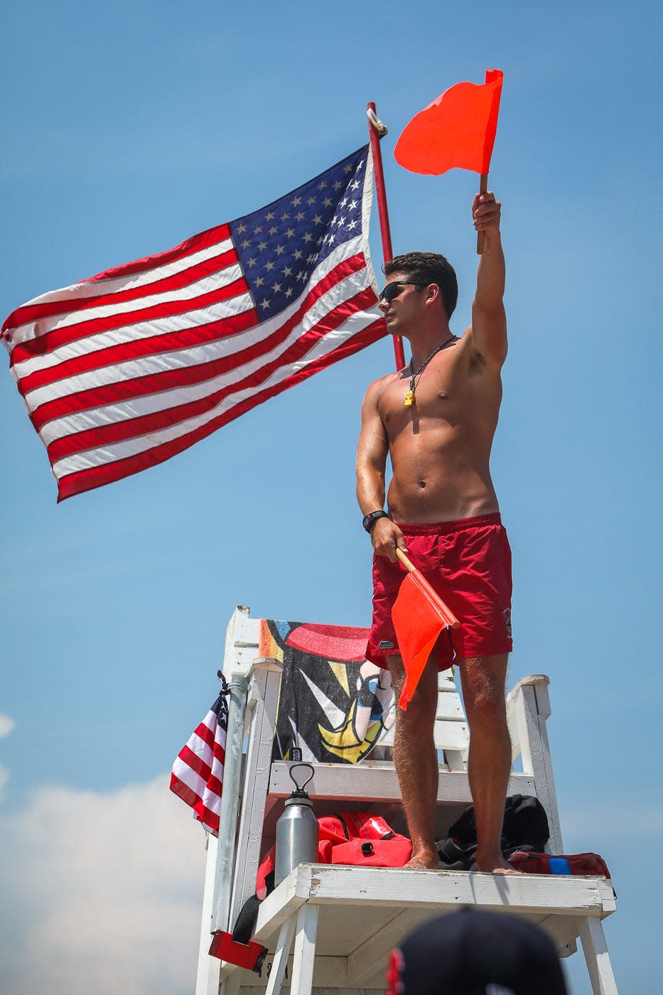 Christian Ellis, a first year member of the Ocean City Beach Patrol, signals to fellow lifeguards on July 4, 2019.