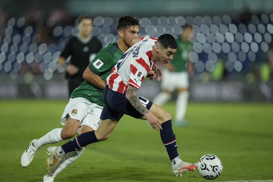 Paraguay's Miguel Almiron, right, fights for the ball with Bolivia's Boris Cespedes during a qualifying soccer match for the FIFA World Cup 2026, at Defensores del Chaco Stadium in Asuncion, Paraguay, Tuesday, Oct. 17, 2023. (AP Photo/Jorge Saenz)