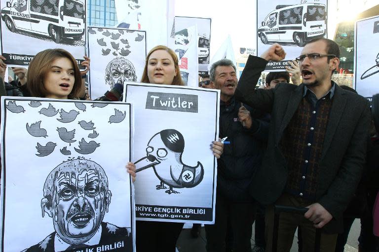 People hold placards as they protest against Turkey's Prime Minister Tayyip Erdogan after the government blocked access to Twitter in Ankara, on March 21, 2014