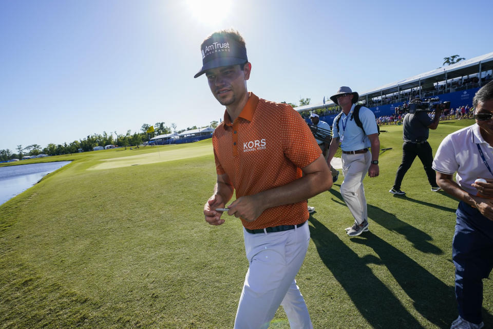 Beau Hossler walks off the 18th green after his teammate Wyndham Clark made a birdie putt to take the lead at the end of the third round of the PGA Zurich Classic golf tournament at TPC Louisiana in Avondale, La., Saturday, April 22, 2023. (AP Photo/Gerald Herbert)