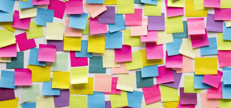 A wall covered in brightly colored post it notes.