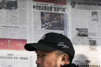 A man reacts after reading a newspaper headline reporting on China's protest against the U.S. shooting down a Chinese balloon at a stand in Beijing, Monday, Feb. 6, 2023. China on Monday accused the United States of indiscriminate use of force when the American military shot down a suspected Chinese spy balloon Saturday, saying that had "seriously impacted and damaged both sides' efforts and progress in stabilizing Sino-U.S. relations." (AP Photo/Andy Wong)