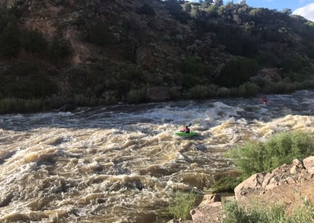 Kayakers in high water on the Rio Grande river south of Pilar New Mexico