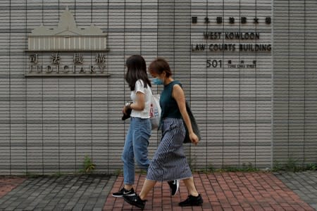 People pass the West Kowloon Law Courts Building in Kowloon, Hong Kong