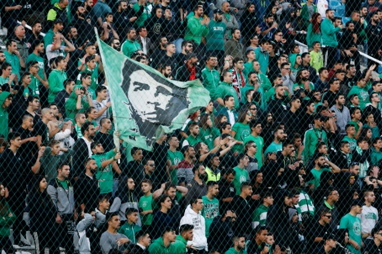 Members of Gate-9, a fan group supporting Nicosia's AC Omonia football team, wave a flag with a portrait of Ernesto "Che" Guevara during a match on November 20, 2016, in the Cypriot capital, Nicosia
