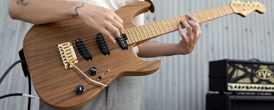 A guitarist plays the Charvel Pro-Mod DK22 SSS 2PT CM Mahogany with Walnut