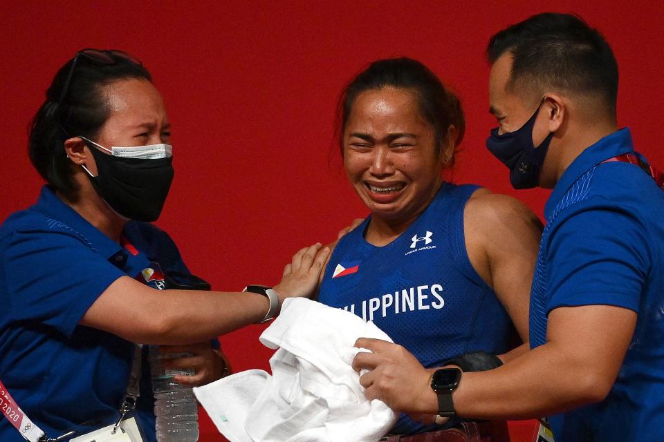 Philippines' Hidilyn Diaz (C) reacts after placing first in the women's 55kg weightlifting competition during the Tokyo 2020 Olympic Games at the Tokyo International Forum in Tokyo on July 26, 2021. (Photo by Vincenzo PINTO / AFP) (Photo by VINCENZO PINTO/AFP via Getty Images)