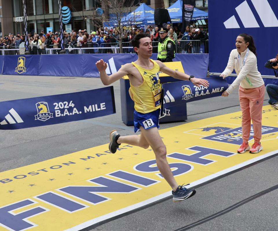 Wellesley's Eli Merritt breaks the tape to win the BAA Boys Scholastic Mile on Saturday, April 13 in Boston.