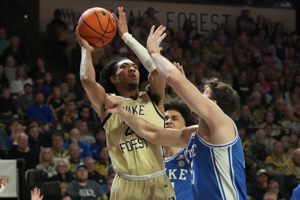 Wake Forest's Hunter Sallis, left, shoots over Duke's Ryan Young, right, during the first half of an NCAA college basketball game in Winston-Salem, N.C., Saturday, Feb. 24, 2024. (AP Photo/Chuck Burton)