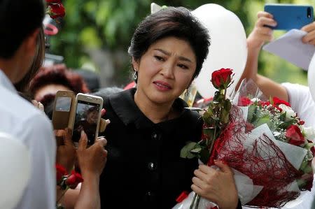 Ousted former Thai prime minister Yingluck Shinawatra greets supporters as she arrives at the Supreme Court in Bangkok, Thailand July 21, 2017. REUTERS/Chaiwat Subprasom