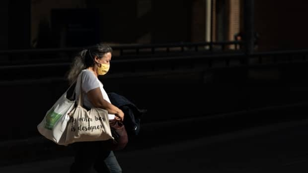 A masked woman walks down a downtown Ottawa street on April 13, 2021. (Andrew Lee/CBC - image credit)