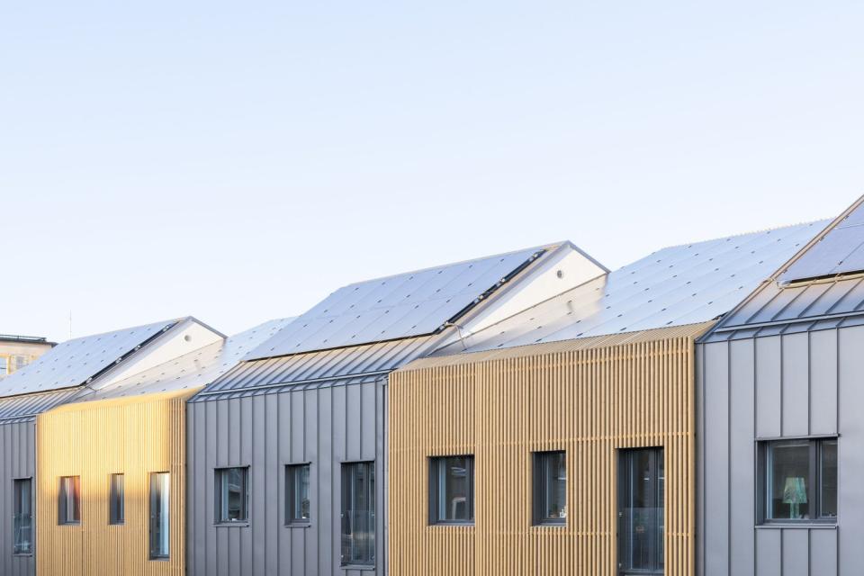 Solar panels line the length of each prefab row house's roof. 