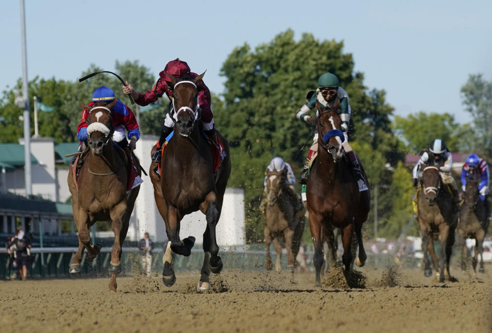 FILE - In this Sept. 4, 2020 file photo, Florent Geroux riding Shedaresthedevil crosses the finish line ahead of Tyler Gaffalione on Swiss Skydiver, left and John Velazquez riding Gamine to win the 146th running of the Kentucky Oaks at Churchill Downs in Louisville, Ky. Gamine, trained by two-time Triple Crown winner Bob Baffert, has tested positive in a post-race drug test for the second time this year, making it the third positive test by a horse in Baffert’s stable in the last six months. Craig Robertson, Baffert’s attorney, issued a statement confirming Gamine’s test results after her third-place finish as the 7-10 favorite in the Kentucky Oaks. (AP Photo/Jeff Roberson, File)