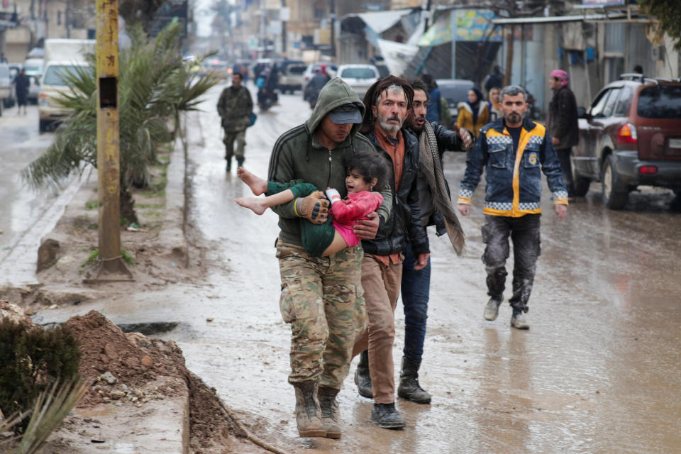 <p>A girl is carried following an earthquake, in rebel-held town of Jandaris, Syria February 6, 2023. REUTERS/Khalil Ashawi</p> 