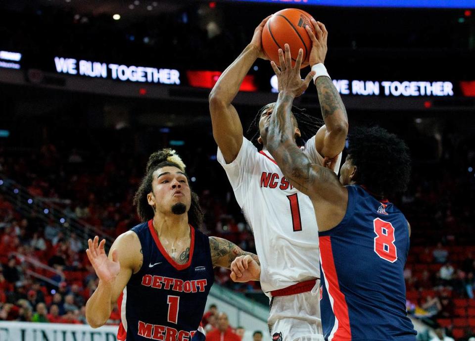 N.C. State’s Jayden Taylor drives to the basket between Detroit’s Mak Manciel and Donovann Toatley during the first half of the Wolfpack’s game on Saturday, Dec. 23, 2023, at PNC Arena in Raleigh, N.C.