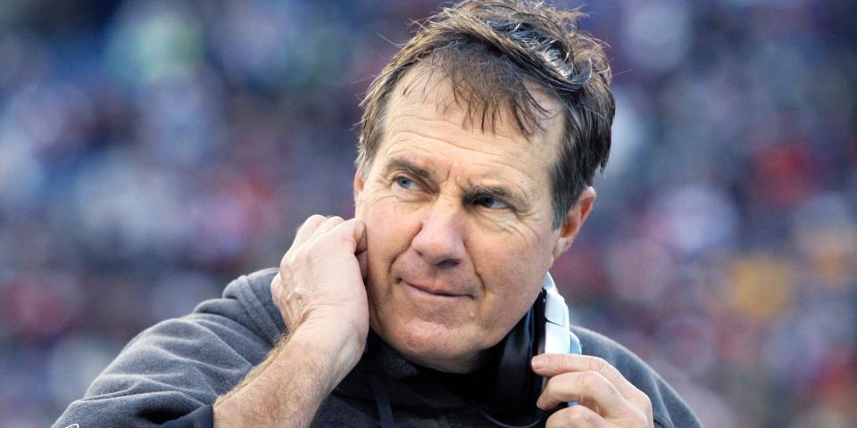 Bill Belichick takes off his headset and smiles during a game in 2009.