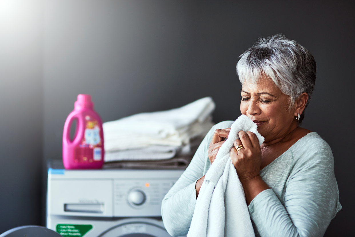 Woman smelling fresh laundry in her laundry room